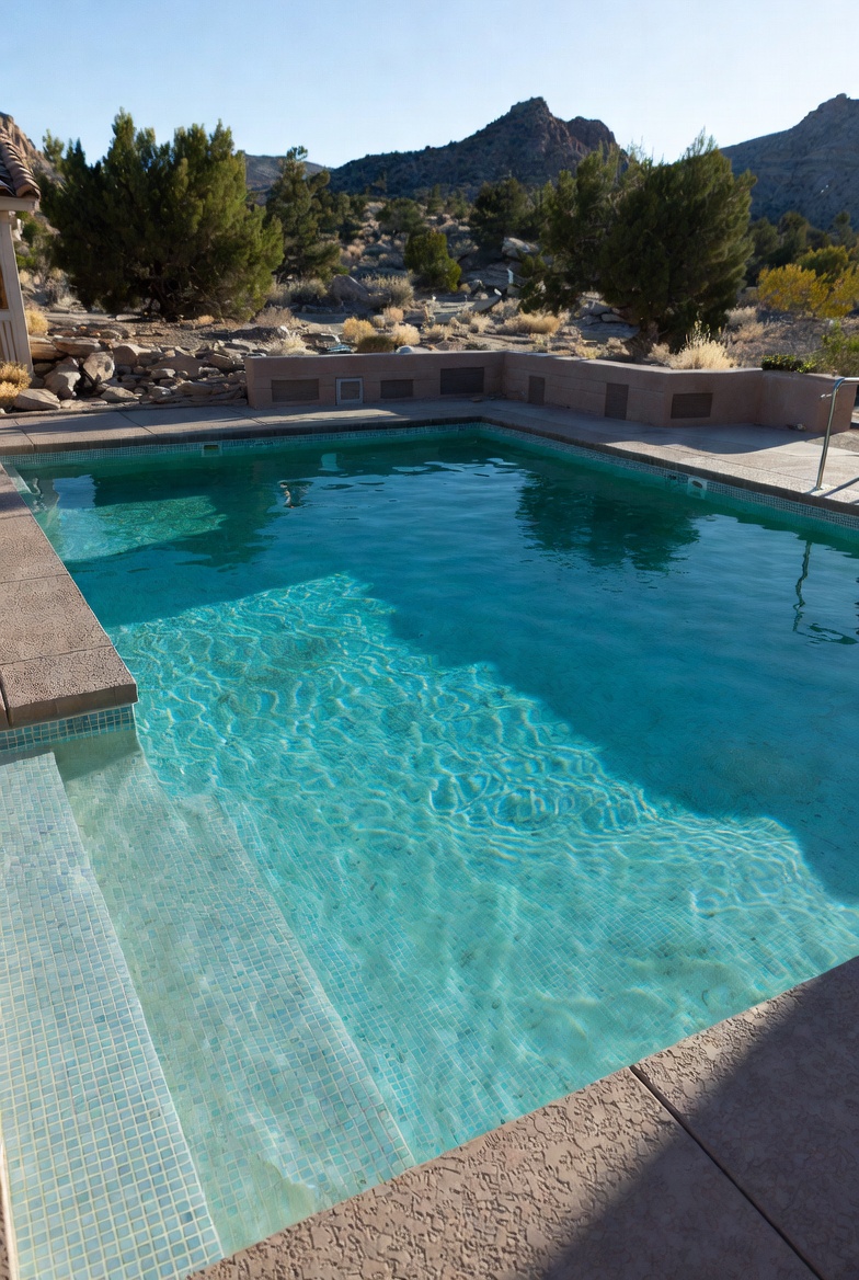 Quartz finish pool in Southern Utah with mosaic tile waterline and mountain backdrop